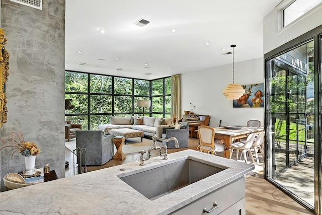 1700 S 6th St, Austin, TX 78704 - kitchen with light stone countertops, a sink, decorative light fixtures, recessed lighting, and white cabinets