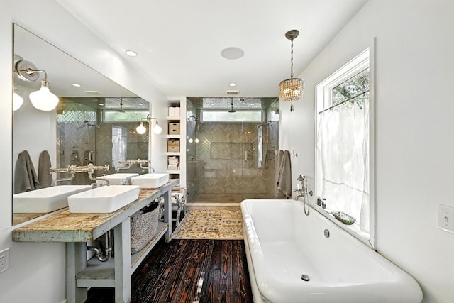 1700 S 6th St, Austin, TX 78704 - bathroom featuring a stall shower, wood finished floors, a soaking tub, and double vanity