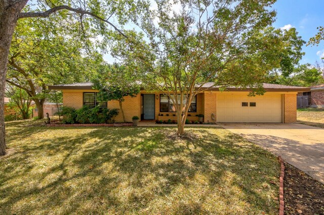 1005 Salem Ln, Austin, TX 78753 - view of front facade featuring brick siding, a garage, driveway, and a front yard