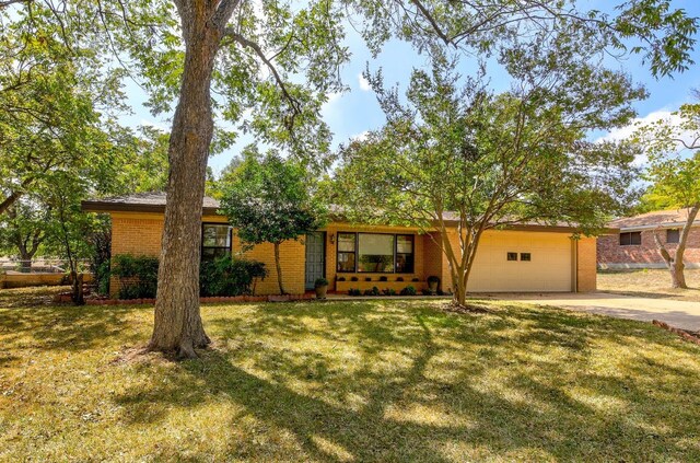 1005 Salem Ln, Austin, TX 78753 - view of front of home with concrete driveway, an attached garage, a front yard, and brick siding