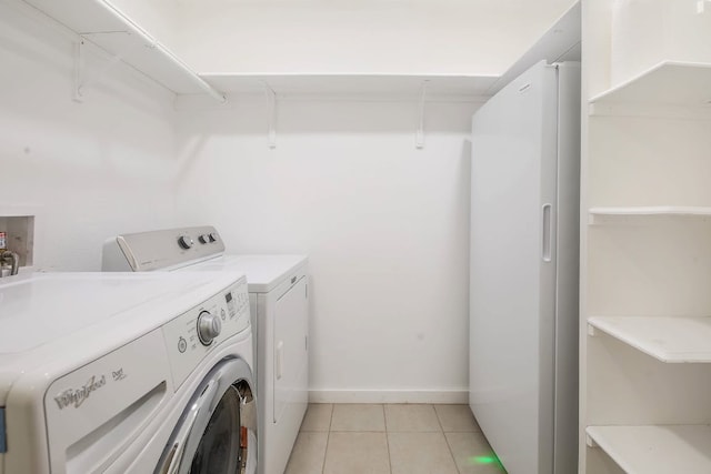 1005 Salem Ln, Austin, TX 78753 - laundry area with washing machine and dryer, light tile patterned floors, and baseboards