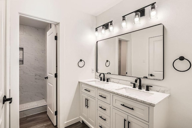 7103 Treasure Cv Unit B, Austin, TX 78745 - bathroom featuring double vanity, wood finished floors, and a tile shower