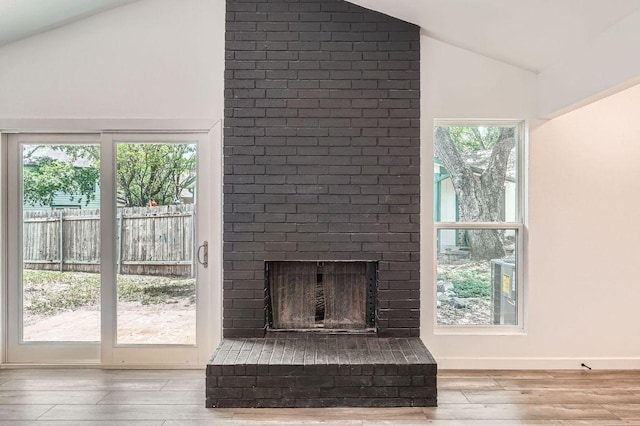 7103 Treasure Cv Unit B, Austin, TX 78745 - unfurnished living room featuring lofted ceiling, wood finished floors, and a fireplace