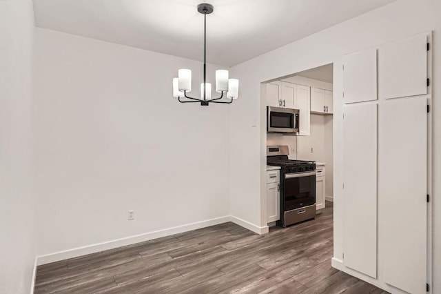 7103 Treasure Cv Unit B, Austin, TX 78745 - kitchen with stainless steel appliances, dark wood-type flooring, a chandelier, white cabinetry, and decorative light fixtures