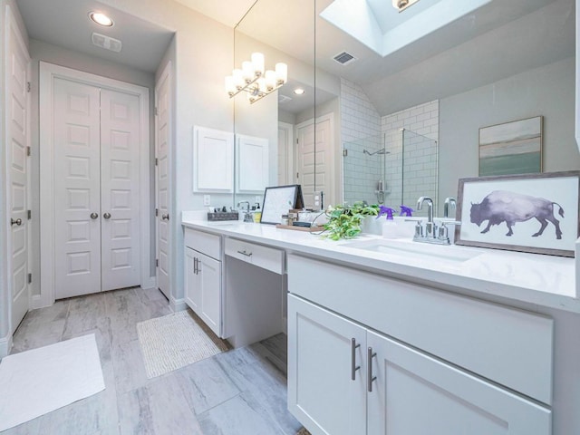 114 Loysoya St, Bastrop, TX 78602 - bathroom with double vanity, a skylight, a tile shower, a chandelier, and a closet