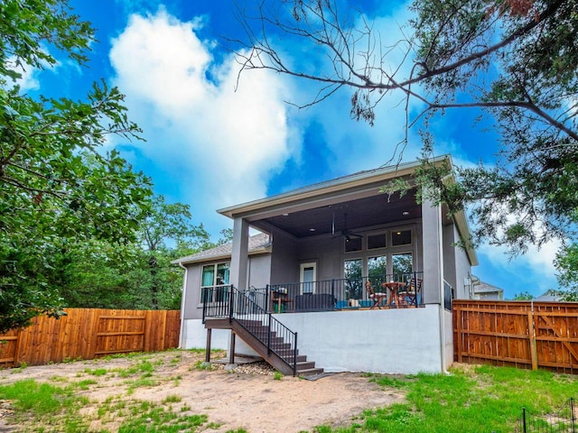 114 Loysoya St, Bastrop, TX 78602 - back of property with a ceiling fan, a fenced backyard, stairs, and stucco siding