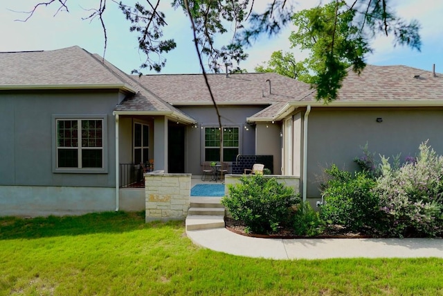 114 Loysoya St, Bastrop, TX 78602 - view of front of house with a front lawn, stucco siding, a shingled roof, and a patio