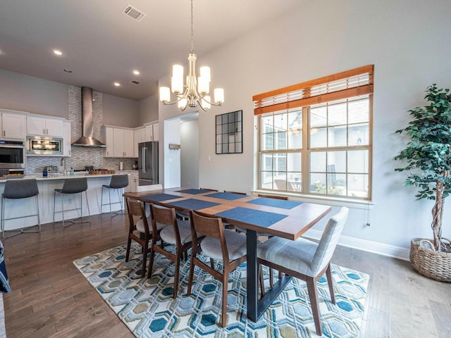 114 Loysoya St, Bastrop, TX 78602 - dining space featuring a chandelier, dark wood-type flooring, baseboards, recessed lighting, and a high ceiling