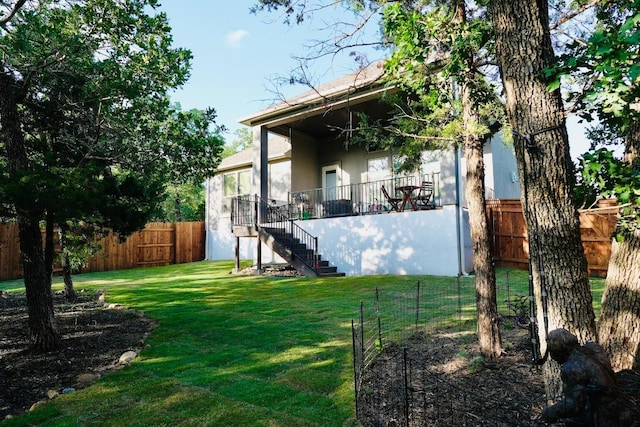114 Loysoya St, Bastrop, TX 78602 - back of property featuring stairway, a fenced backyard, and stucco siding