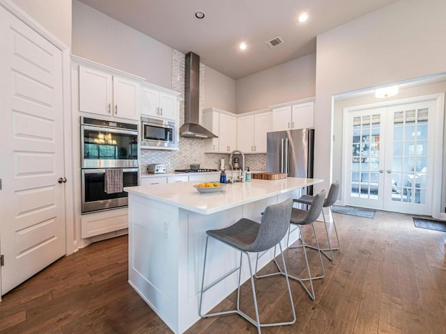 114 Loysoya St, Bastrop, TX 78602 - kitchen with stainless steel appliances, wall chimney range hood, dark wood-type flooring, french doors, and light countertops