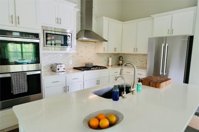 114 Loysoya St, Bastrop, TX 78602 - kitchen with wall chimney exhaust hood, stainless steel appliances, light countertops, and tasteful backsplash