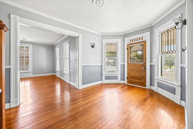 1223 Cecelia St, Taylor, TX 76574 - entryway with hardwood / wood-style flooring, plenty of natural light, a textured ceiling, and ornamental molding