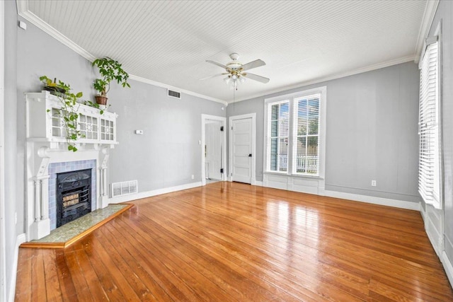 1223 Cecelia St, Taylor, TX 76574 - unfurnished living room featuring ceiling fan, wood-type flooring, a tile fireplace, and crown molding