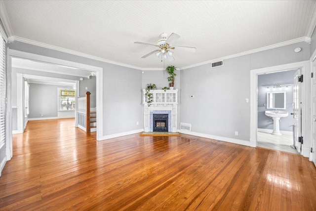 1223 Cecelia St, Taylor, TX 76574 - unfurnished living room featuring hardwood / wood-style floors, a ceiling fan, a fireplace, and crown molding