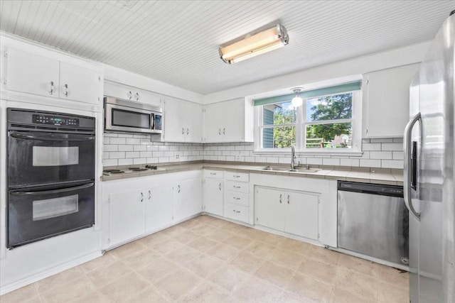 1223 Cecelia St, Taylor, TX 76574 - kitchen with stainless steel appliances, a sink, decorative backsplash, and white cabinets