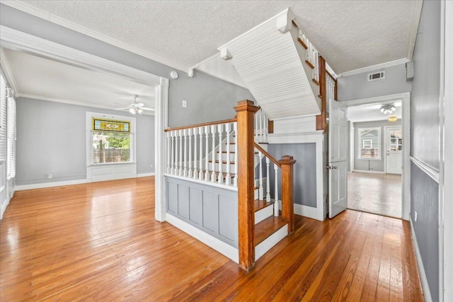 1223 Cecelia St, Taylor, TX 76574 - hall featuring hardwood / wood-style floors, crown molding, stairway, a textured ceiling, and baseboards