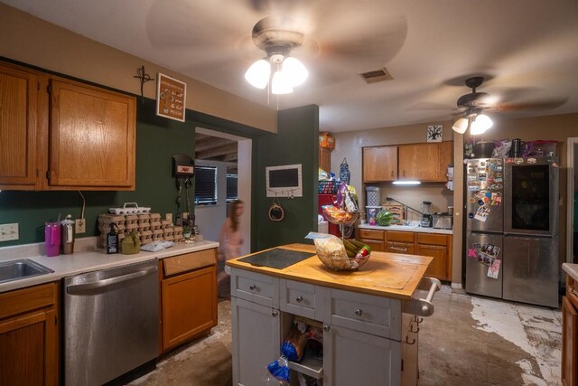 178 Ann Powell Rd, Smithville, TX 78957 - kitchen featuring stainless steel appliances, a ceiling fan, brown cabinets, and wood counters
