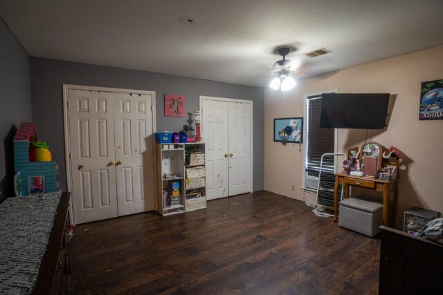 178 Ann Powell Rd, Smithville, TX 78957 - bedroom featuring multiple closets, dark wood finished floors, and a ceiling fan