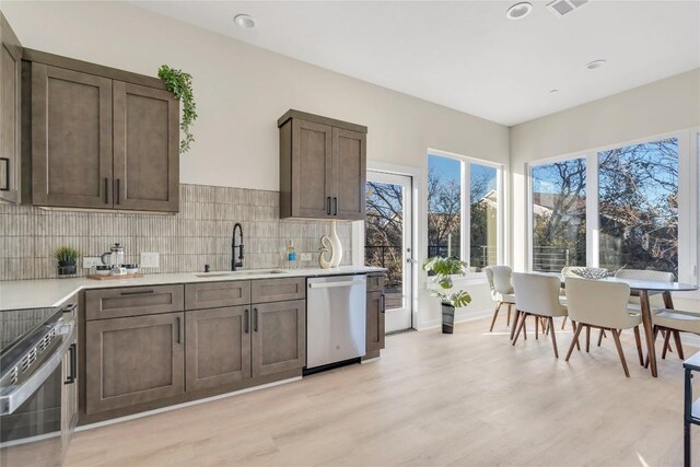 2309 Montopolis Dr Unit 8, Austin, TX 78741 - kitchen with appliances with stainless steel finishes, light wood-type flooring, light countertops, tasteful backsplash, and recessed lighting