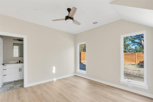 2309 Montopolis Dr Unit 8, Austin, TX 78741 - unfurnished bedroom with light wood finished floors, ensuite bathroom, and vaulted ceiling