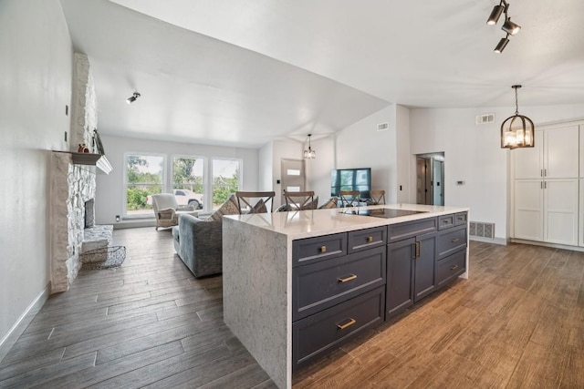 9600 Claxton Dr, Austin, TX 78736 - kitchen featuring vaulted ceiling, dark wood-style floors, open floor plan, light countertops, and a kitchen island