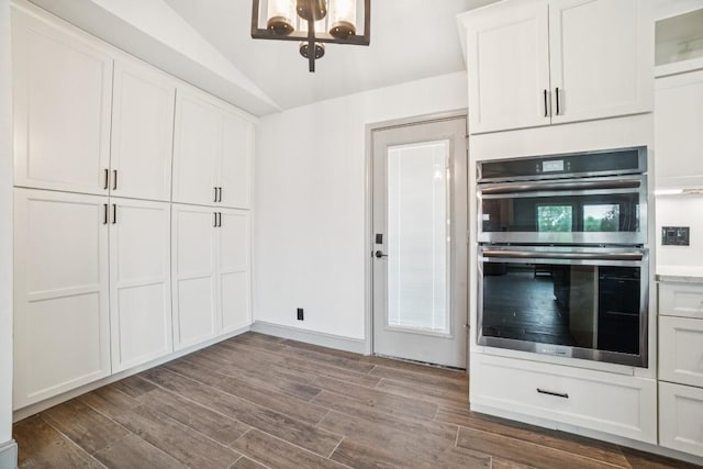 9600 Claxton Dr, Austin, TX 78736 - kitchen featuring stainless steel double oven, a chandelier, dark wood-style floors, lofted ceiling, and white cabinets