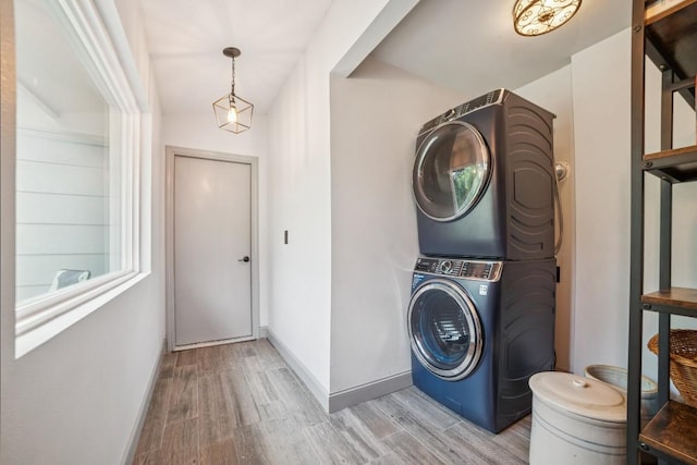9600 Claxton Dr, Austin, TX 78736 - washroom with stacked washer and clothes dryer, light wood-style flooring, and baseboards