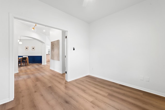 10021 Mirage Cv, Austin, TX 78717 - unfurnished room with arched walkways, light wood finished floors, and baseboards