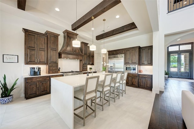 8100 Magnolia Ridge Cv, Austin, TX 78738 - kitchen featuring built in appliances, custom range hood, dark brown cabinetry, a towering ceiling, and beam ceiling