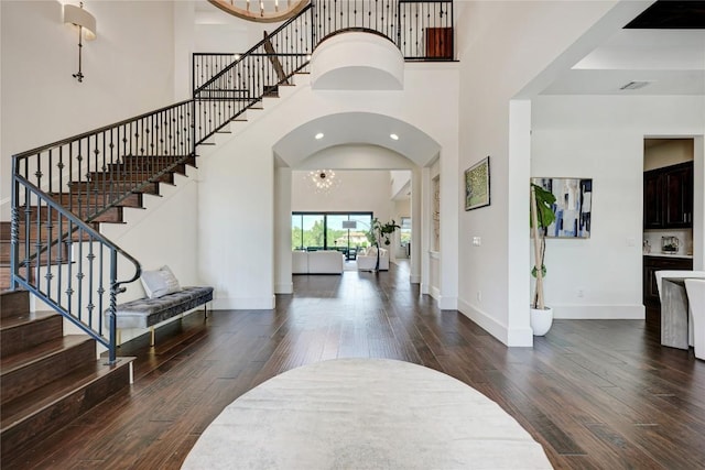 8100 Magnolia Ridge Cv, Austin, TX 78738 - foyer entrance with a high ceiling, dark wood-type flooring, stairway, a chandelier, and arched walkways