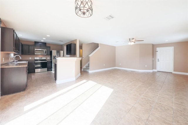 9001 Edmundsbury Dr, Austin, TX 78747 - kitchen with appliances with stainless steel finishes, ceiling fan, light tile patterned flooring, open floor plan, and baseboards
