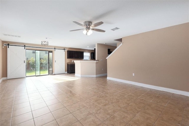9001 Edmundsbury Dr, Austin, TX 78747 - unfurnished living room with a barn door, a ceiling fan, baseboards, and light tile patterned flooring