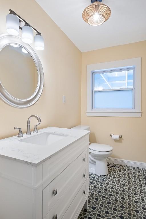 1003 E 13th St Unit 1, Austin, TX 78702 - bathroom with vanity, baseboards, toilet, and tile patterned floors