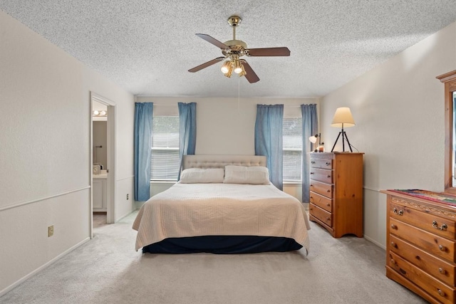 534 Broken Feather Trl, Pflugerville, TX 78660 - bedroom with a textured ceiling, multiple windows, light carpet, and ensuite bathroom