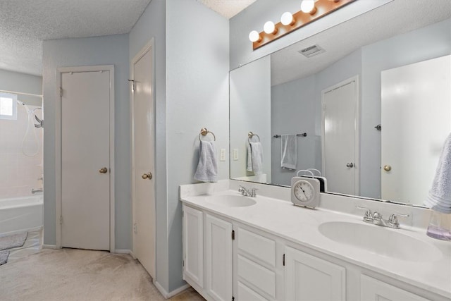 534 Broken Feather Trl, Pflugerville, TX 78660 - bathroom featuring double vanity, a textured ceiling, and  shower combination