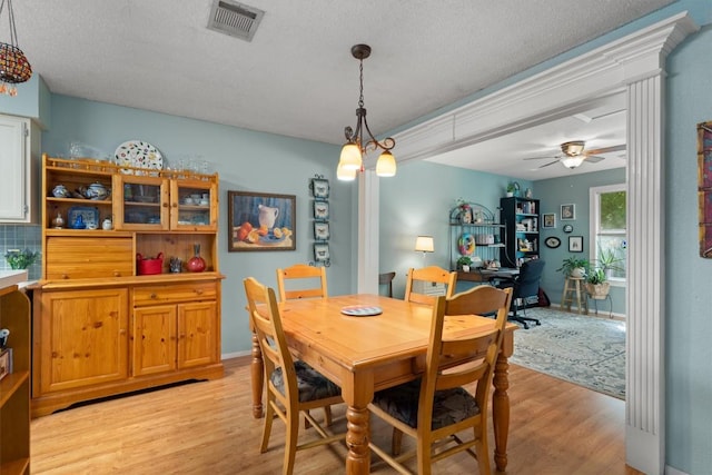 534 Broken Feather Trl, Pflugerville, TX 78660 - dining room with light wood finished floors, a ceiling fan, a textured ceiling, and a desk