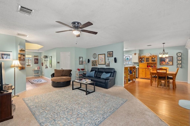 534 Broken Feather Trl, Pflugerville, TX 78660 - living room with ceiling fan, a textured ceiling, a chandelier, and wood finished floors
