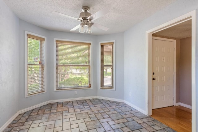 8546 Red Willow Dr, Austin, TX 78736 - spare room featuring ceiling fan, light stone finish floors, and a textured ceiling