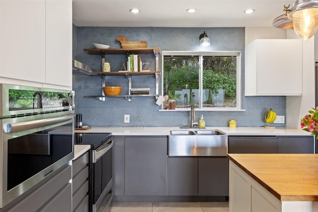 108 Highlander St, Lakeway, TX 78734 - kitchen with stainless steel appliances, tasteful backsplash, white cabinetry, wooden counters, and recessed lighting