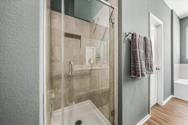 1725 Cobblecrest Ln, Leander, TX 78641 - full bathroom featuring a textured wall, a stall shower, wood finished floors, and a tub