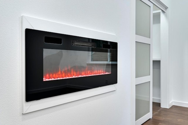 1006 Chericoo St, Austin, TX 78702 - detailed view of wood finished floors, a lit fireplace, and baseboards