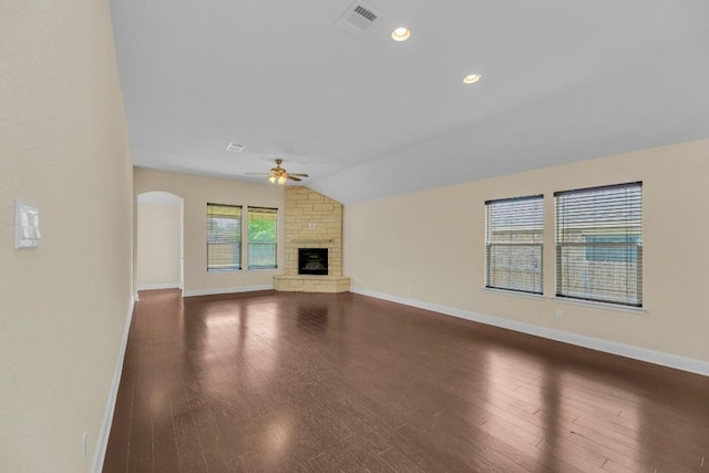 3546 Guadalajara St, Round Rock, TX 78665 - unfurnished living room with a ceiling fan, lofted ceiling, dark wood finished floors, a stone fireplace, and arched walkways