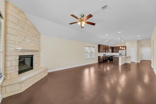 3546 Guadalajara St, Round Rock, TX 78665 - unfurnished living room with ceiling fan, lofted ceiling, a fireplace, dark wood-type flooring, and arched walkways