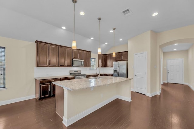 3546 Guadalajara St, Round Rock, TX 78665 - kitchen with stainless steel appliances, arched walkways, an island with sink, dark wood-style flooring, and dark brown cabinets