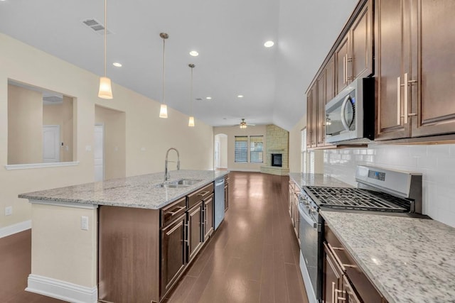 3546 Guadalajara St, Round Rock, TX 78665 - kitchen featuring stainless steel appliances, backsplash, ceiling fan, open floor plan, and light stone counters