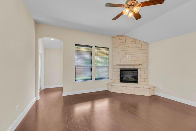 3546 Guadalajara St, Round Rock, TX 78665 - unfurnished living room featuring wood finished floors, a ceiling fan, a stone fireplace, arched walkways, and lofted ceiling