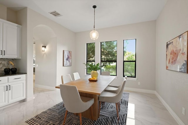 106 Cactus Bend Cv, Georgetown, TX 78633 - dining area with light marble finish floors, arched walkways, and baseboards