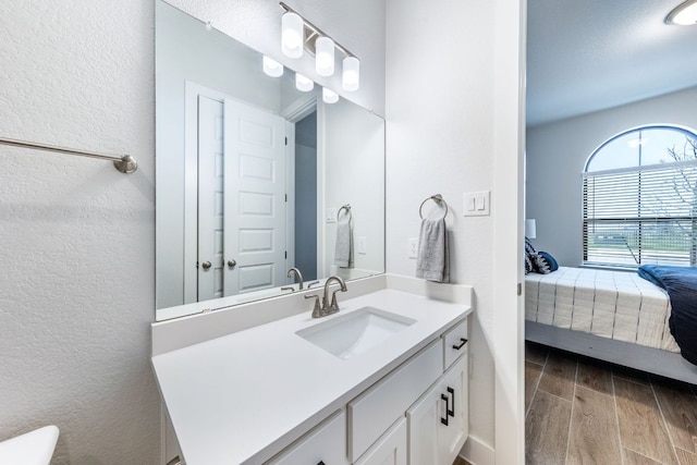 471 Diamondleaf Dr, Buda, TX 78610 - bathroom with ensuite bathroom, vanity, a textured wall, and wood finished floors