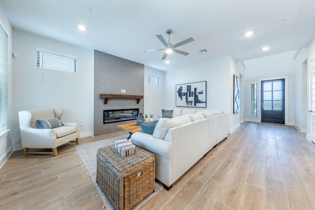 471 Diamondleaf Dr, Buda, TX 78610 - living room featuring light wood-type flooring, a ceiling fan, a large fireplace, baseboards, and recessed lighting