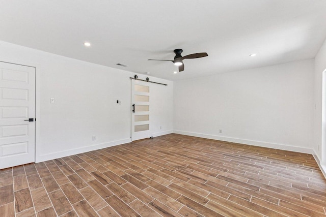 1111 Spearson Ln, Austin, TX 78745 - spare room with a barn door, a ceiling fan, wood finished floors, and recessed lighting